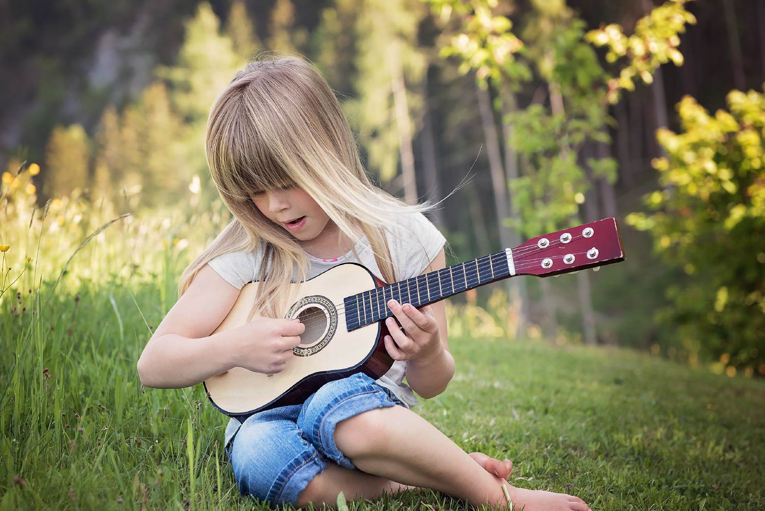 Ein Mädchen lernt autodidaktisch Gitarre spielen.